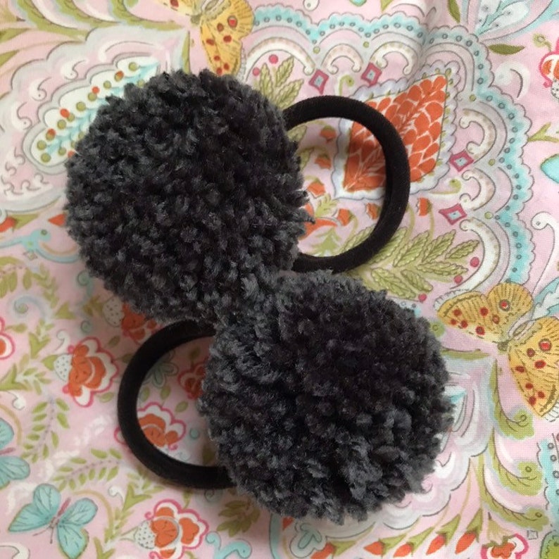 Set of two gray yarn pom pom hair ties on balck elastics