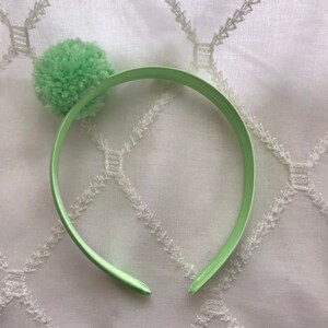 Sweet sea foam green yarm pom pom headband on coordinating satin covered headband