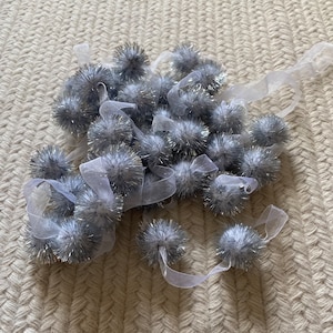 Silver tinsel pom pom garland on white organza ribbon