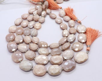 May include: A strand of oval-shaped moonstone beads with a light pink hue. The beads are faceted and have a shimmery, iridescent finish. The strand is finished with a tassel on each end.