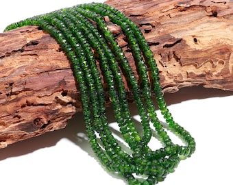 May include: A strand of green gemstone beads, likely peridot, with a faceted finish. The beads are strung together on a clear thread and are arranged in a loose, flowing pattern.
