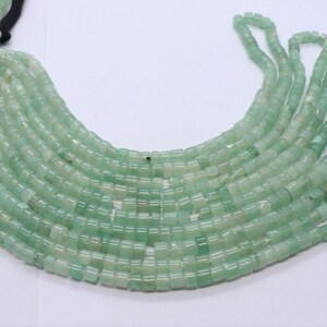 May include: A strand of light green jade beads, each bead is a square with rounded edges.