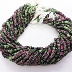 May include: A strand of green and pink gemstone beads. The beads are round and have a smooth, polished finish.