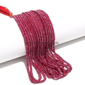 Op de afbeelding: Een streng dieprode robijn kralen, elke kraal is rond en licht facetgeslepen. De kralen zijn geregen op een dun draad en zijn ongeveer 4 mm in diameter.