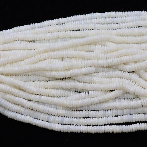 May include: A strand of white shell beads, each bead is a small, flat disc with a slightly rounded edge.