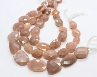 May include: A strand of peach-coloured sunstone beads with a faceted, teardrop shape. The beads are strung on white thread.