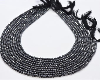 May include: A strand of black faceted gemstone beads, strung on a cord with tassels at the ends. The beads are small and uniform in size, creating a sleek and elegant look.