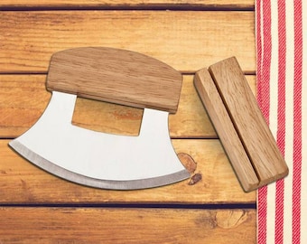 May include: A wooden handled curved knife with a stainless steel blade. The knife is on a wooden surface with a red and white striped fabric in the background.