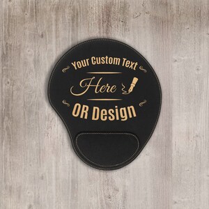 May include: Black leather mouse pad with a gold stitched border. The pad has a gold inscription that reads "Your Custom Text Here OR Design" with a pen and ink illustration.