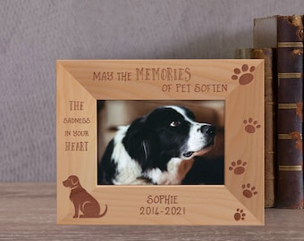 May include: A wooden photo frame with a paw print design and the text "May the memories of pet soften the sadness in your heart". The frame has a photo of a black and white dog and the text "Sophie 2014-2021".