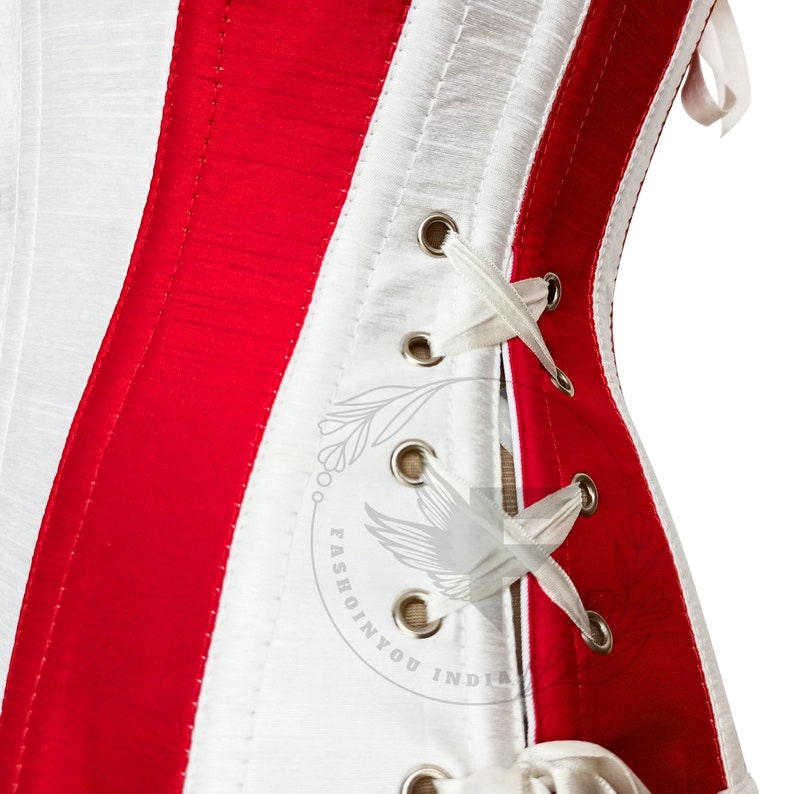 Red and white silk overbust corset with steel boning; white lacing through silver grommets, side view.