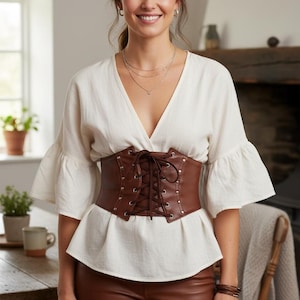 a female model is showcasing brown leather underbust corset belt
