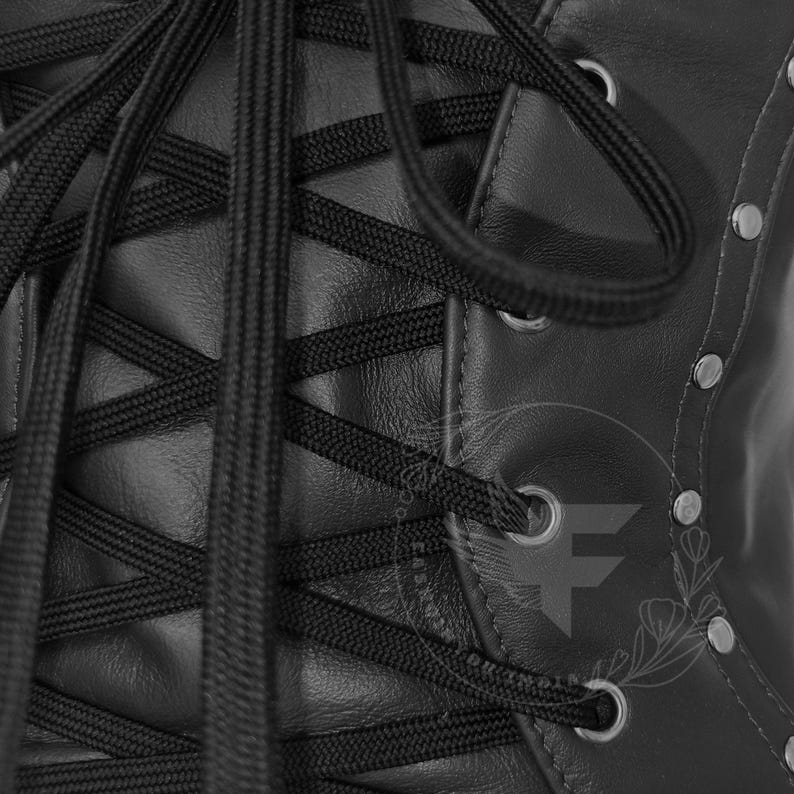 Black leather underbust corset belt with crisscross lacing, metal eyelets, reinforced panels.