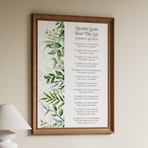 Può includere: Una stampa artistica incorniciata con il poema Children Learn What They Live di Dorothy Law Nolte. Il testo è stampato in nero su sfondo bianco, decorato con un bordo verticale di foglie ad acquerello verdi sul lato sinistro dell'opera.