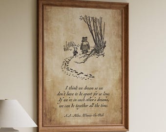 Puede incluir: Un cuadro enmarcado con una ilustración de Winnie the Pooh y una cita sobre los sueños. La obra de arte representa a Pooh y Piglet en un camino. El marco es de color marrón cálido y la impresión tiene un aspecto de papel vintage.