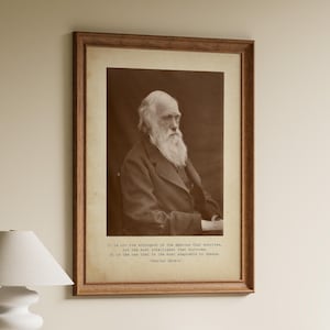Puede incluir: Un retrato enmarcado en tono sepia de Charles Darwin con una larga barba blanca, vistiendo un abrigo oscuro. Debajo del retrato, el texto dice: It is not the strongest of the species that survives, nor the most intelligent that survives. It is the one that is the most adaptable to change. Charles Darwin.