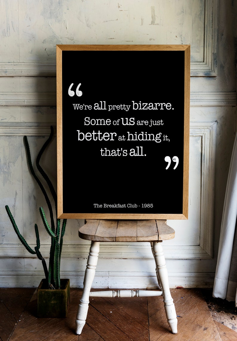 May include: A black framed print with a white background and white text. The text reads "We're all pretty bizarre. Some of us are just better at hiding it, that's all."  The text is in quotation marks and below the text is "The Breakfast Club - 1985".
