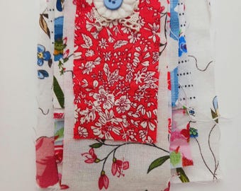 May include: A patchwork of fabric scraps in various floral patterns, including red, white, and blue, with a white button and lace trim.