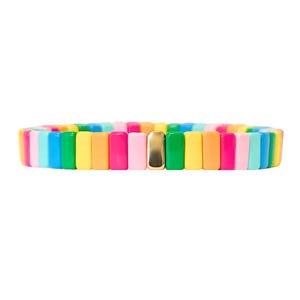 May include: A colourful rainbow bracelet with a gold accent. The bracelet is made of rectangular beads in various colours, including red, orange, yellow, green, blue, and purple.