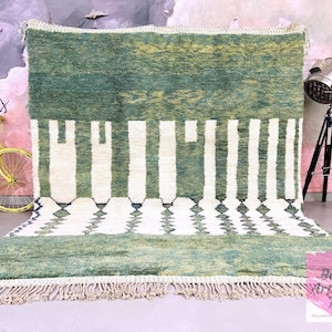 Green Moroccan rug with ivory geometric design, displayed in boho room with vintage yellow bike and tripod lamp – handmade wool rug for living room