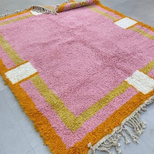 Plush Berber rug with a modern geometric border design.