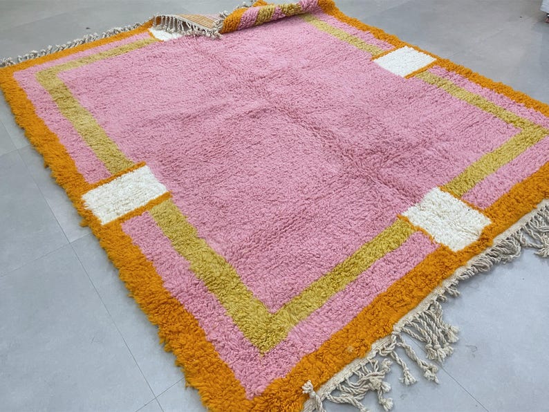 Plush Berber rug with a modern geometric border design.