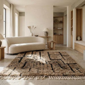 May include: A neutral-toned living room with a beige sofa, wooden side tables, and a patterned rug. The rug features a geometric design in black and brown. The room is bathed in natural light, creating a warm and inviting atmosphere.
