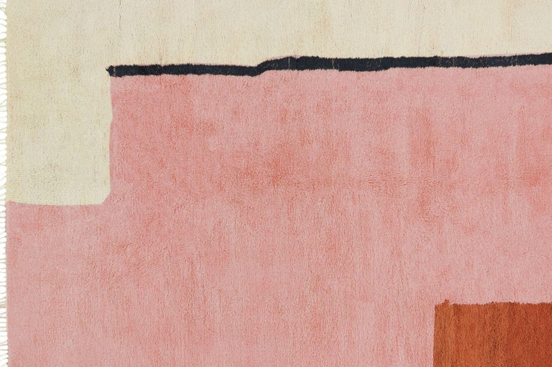 K&ouml;nnte beinhalten: Abstrakter geometrischer Teppich in Creme-, Rosa- und Oranget&ouml;nen. Der Teppich hat einen dicken, strukturierten Flor.