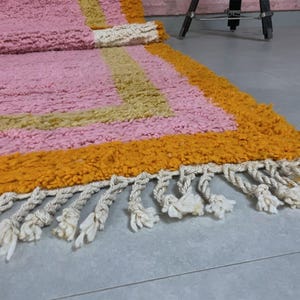 Soft pink Moroccan rug, perfect for a cozy and stylish living space.
