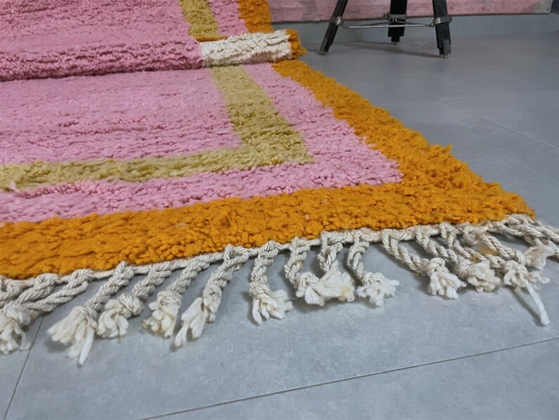 Soft pink Moroccan rug, perfect for a cozy and stylish living space.
