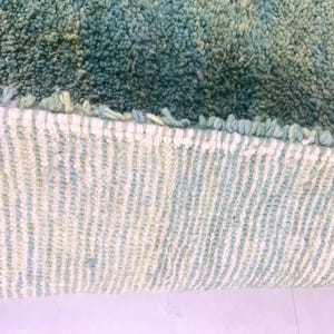 Detailed shot of rug edge with tight weaving and two-tone wool threads – durable handmade green Moroccan rug for boho homes