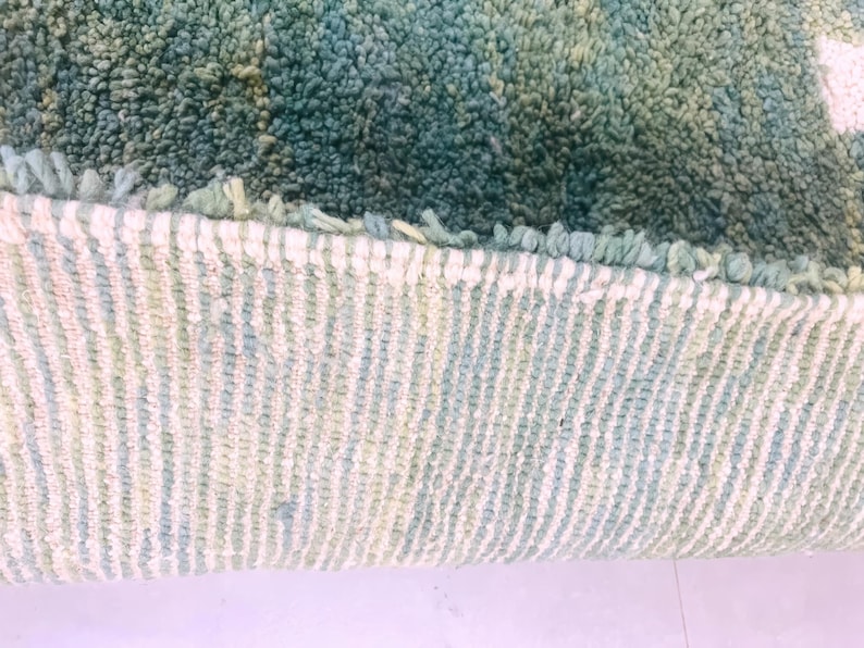 Detailed shot of rug edge with tight weaving and two-tone wool threads – durable handmade green Moroccan rug for boho homes