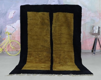 Könnte beinhalten: Ein schwarzer und goldener Teppich mit geometrischem Muster. Der Teppich hat einen schwarzen Rand und zwei goldene Rechtecke in der Mitte.