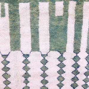 Detailed shot of Moroccan rug’s center with vertical white stripes and emerald green wool – artisan craftsmanship and rich texture