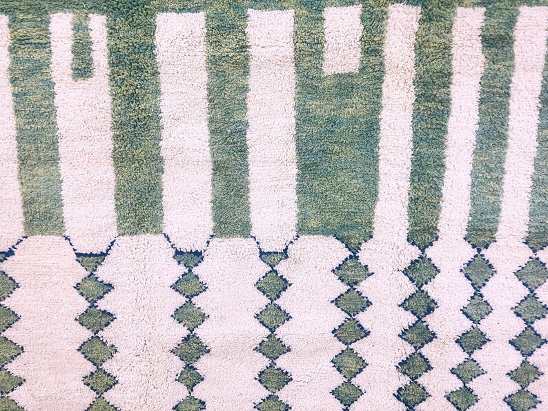 Detailed shot of Moroccan rug’s center with vertical white stripes and emerald green wool – artisan craftsmanship and rich texture
