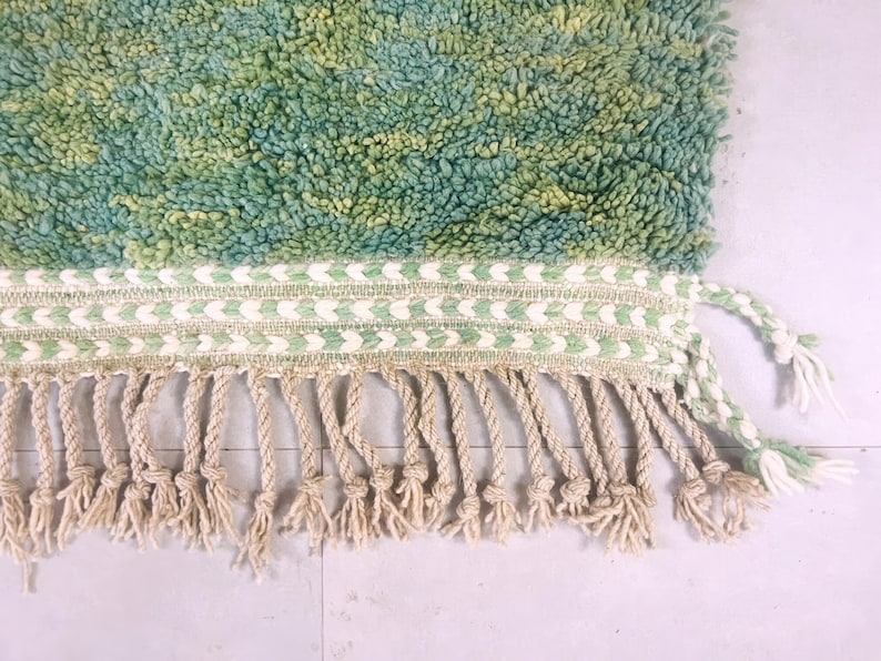 Close-up of hand-knotted fringe and mint green edge finish – traditional Moroccan rug made with natural wool