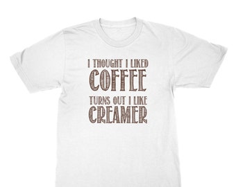 May include: White t-shirt with brown text that reads "I thought I liked coffee turns out I like creamer".