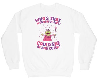 May include: White sweatshirt with a green puppet character wearing a pink dress and holding a wand. The text on the sweatshirt reads "Who's that wonderful girl? Could she be any cuter?"