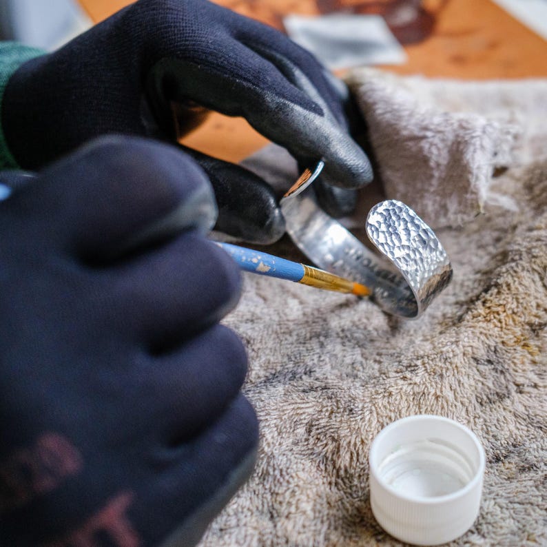 a person wearing gloves and holding a pair of scissors