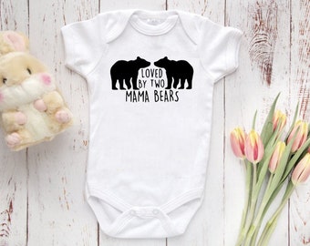 May include: White baby onesie with black bear silhouettes and the text "Loved by two mama bears".