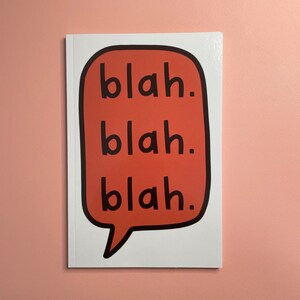 May include: A white card with a red speech bubble that says "blah. blah. blah." in black text.