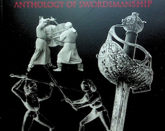 Op de afbeelding: Een zwart-witte boekomslag met de titel "SPADA ANTHOLOGIE VAN DE ZWAARDVECHTKUNST". De omslag toont een zwaard met een versierd handvat en twee figuren in schermkunstposes.