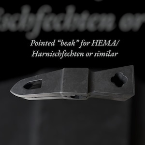 Puede incluir: Un objeto met&aacute;lico negro y puntiagudo con forma de pico, con un recorte rectangular y un agujero en forma de tr&eacute;bol. Texto: "Pointed 'beak' for HEMA/ Harnischfechten or similar."