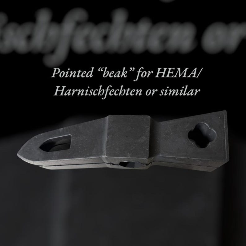 Puede incluir: Un objeto met&aacute;lico negro y puntiagudo con forma de pico, con un recorte rectangular y un agujero en forma de tr&eacute;bol. Texto: "Pointed 'beak' for HEMA/ Harnischfechten or similar."