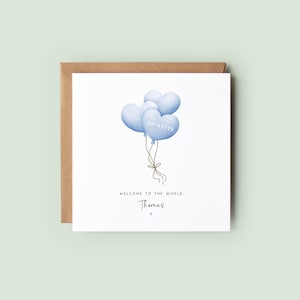 Personalised new baby boy card with blue heart balloons and birth date, featuring the name “Thomas” and soft neutral styling – a keepsake welcome to the world card.