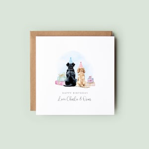 Pu&ograve; includere: Un biglietto di compleanno con illustrazioni ad acquerello di due cani con cappelli da festa, seduti schiena contro schiena. Il biglietto dice "Happy Birthday" e "Love Charlie & Oscar". Il biglietto &egrave; su una busta marrone.
