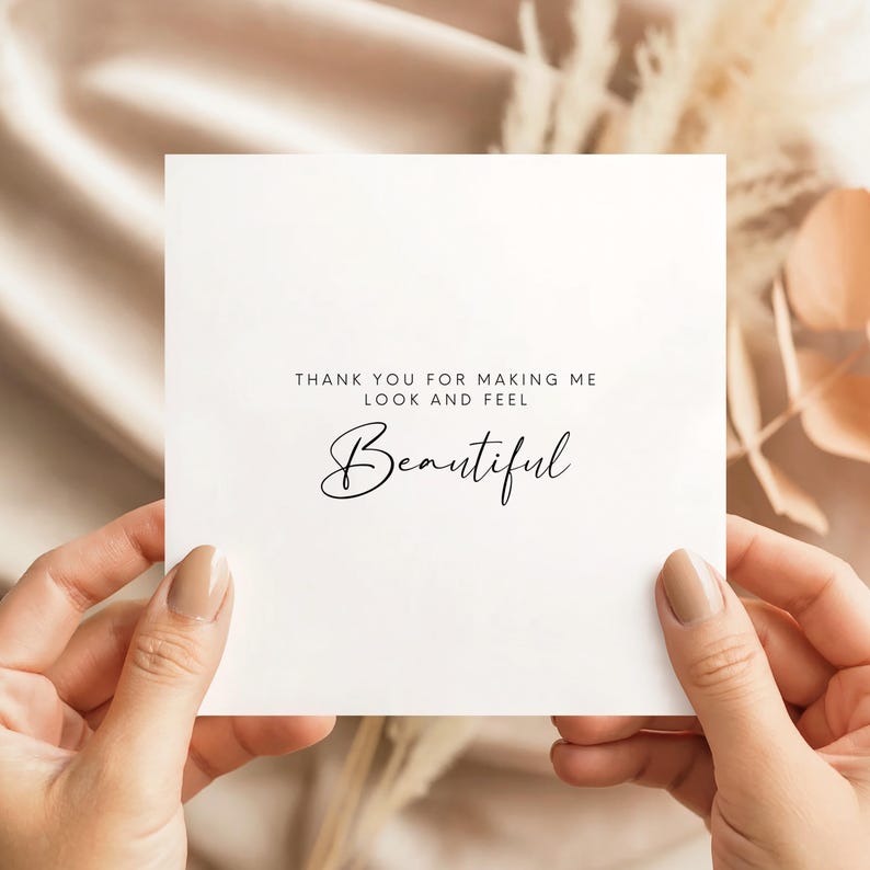 Minimal wedding thank you card with text “Thank you for making me look and feel beautiful” in modern typography, shown in a neutral styled mock-up held in hands.