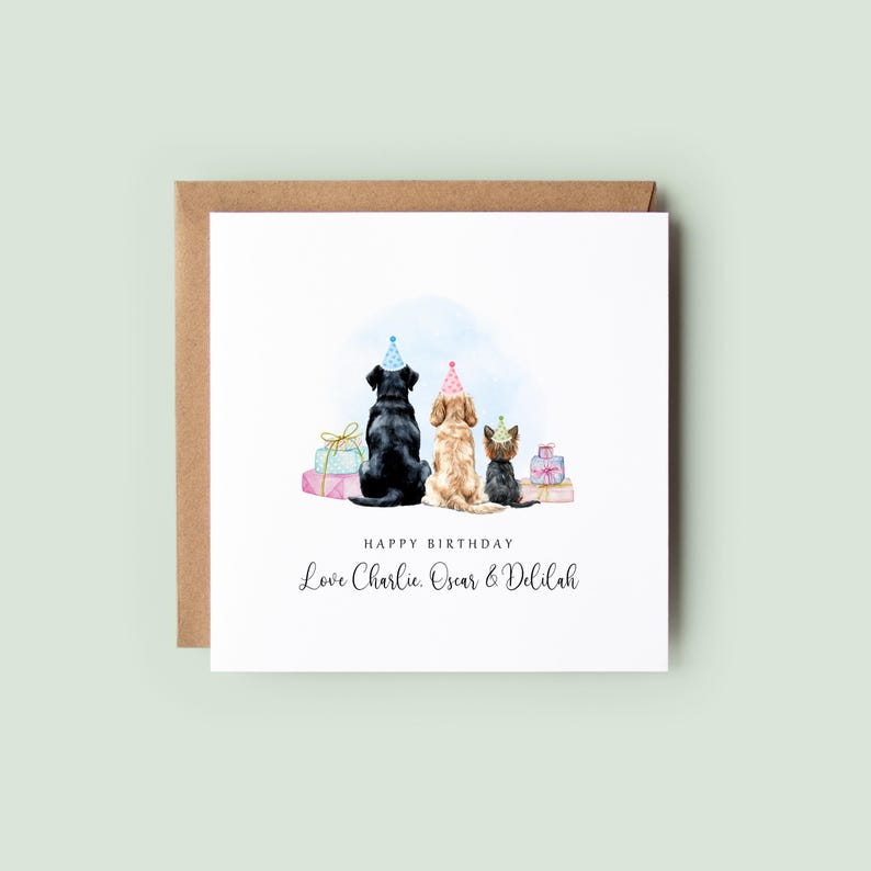 Pu&ograve; includere: Un biglietto di compleanno con illustrazioni ad acquerello di tre cani con cappelli da festa, con regali e la scritta "Happy Birthday". La carta include il testo "Love Charlie, Oscar & Delilah."