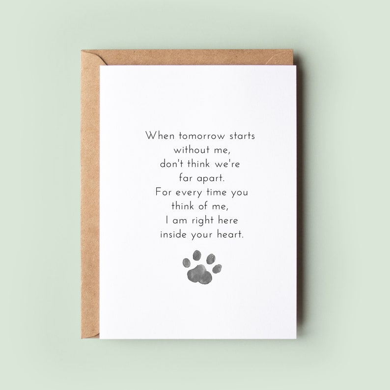 May include: A white card with a black paw print and the text "When tomorrow starts without me, don't think we're far apart. For every time you think of me, I am right here inside your heart."
