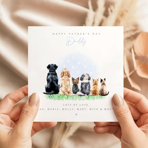 May include: A Father's Day card featuring a watercolor illustration of six pets: a black Labrador, a golden retriever, a Yorkie, a Shih Tzu, an orange tabby, and a Siamese cat. The card reads "Happy Father's Day Daddy" and "Lots of Love."
